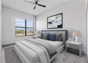 Thumbnail 1 of 25 - a white bedroom with a white bed and a ceiling fan