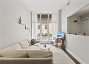 Thumbnail 34 of 35 - a living room with a couch and a coffee table    and a window