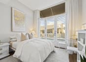 Thumbnail 17 of 35 - a bedroom with a bed and a large window