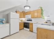 Thumbnail 30 of 35 - a kitchen with white appliances and wooden cabinets