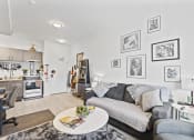 Thumbnail 3 of 24 - a living room with a gray couch and a white table