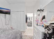 Thumbnail 9 of 24 - a bedroom with white walls and a bed and a white dresser