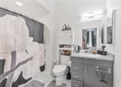 Thumbnail 8 of 24 - a bathroom with a shower and a sink and a toilet