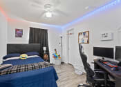 Thumbnail 26 of 26 - a bedroom with a bed and a desk and a tv