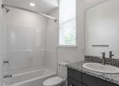 Thumbnail 16 of 24 - A white bathroom with a toilet, sink, and bathtub.