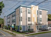 Thumbnail 24 of 24 - A modern apartment building with a blue and beige facade.