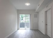 Thumbnail 22 of 24 - A room with a sliding glass door leading to a balcony.