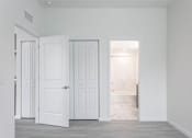 Thumbnail 17 of 24 - A room with white doors and a grey floor.