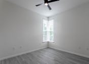 Thumbnail 19 of 24 - A room with a ceiling fan and a window with blinds.