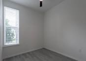 Thumbnail 20 of 24 - A room with a window and wooden flooring.