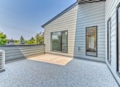 Thumbnail 9 of 73 - A house with a grey siding and a glass door.