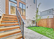 Thumbnail 5 of 73 - A house with a wooden staircase leading to a glass door.