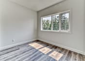 Thumbnail 20 of 73 - A room with a window and a wooden floor.