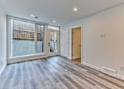 Thumbnail 10 of 73 - A room with a wooden floor and a glass door leading to a balcony.