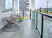 Thumbnail 6 of 11 - A balcony with a table and chairs.