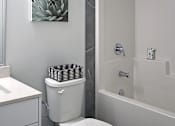 Thumbnail 11 of 11 - A white toilet sits next to a sink in a bathroom.