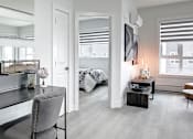 Thumbnail 4 of 11 - A modern bedroom with a large mirror above a vanity table.