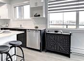 Thumbnail 9 of 11 - A modern kitchen with a white countertop and stainless steel appliances.