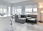 Thumbnail 7 of 11 - A modern kitchen with a white island and black cabinets.