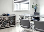 Thumbnail 5 of 11 - A white room with a table and chairs.