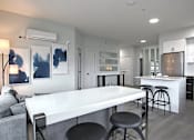 Thumbnail 8 of 11 - A modern kitchen with a white island and bar stools.