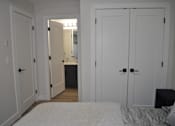 Thumbnail 3 of 9 - A bedroom with a bed, a mirror, and a dresser at The Laurent at Laurel Apartments, Edmonton, T6T 2T5