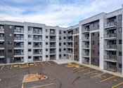 Thumbnail 4 of 31 - A parking lot in front of apartment buildings.at The Pointe at Riverview, Edmonton, AB T6M 3H4