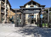 Thumbnail 2 of 10 - a gate is open in front of a building with a playground in the background
