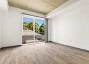 Thumbnail 12 of 35 - A room with a sliding glass door leading to a backyard.