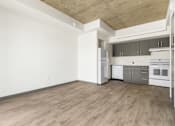 Thumbnail 5 of 35 - A kitchen with white appliances and wooden floors.