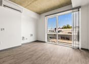 Thumbnail 7 of 35 - A room with a sliding glass door leading to a balcony.