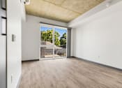 Thumbnail 8 of 35 - A room with a sliding glass door leading to a backyard.