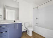 Thumbnail 21 of 35 - A white toilet sits next to a white sink in a bathroom.
