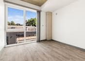 Thumbnail 6 of 35 - A room with a sliding glass door leading to a balcony.