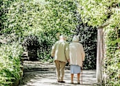 Thumbnail 4 of 15 - an elderly couple walking down a garden path