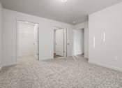 Thumbnail 7 of 13 - A white room with carpeted floor and three doors.