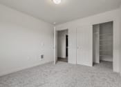Thumbnail 13 of 13 - A white room with a carpeted floor and a doorway leading to another room.