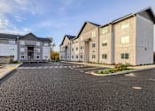 Thumbnail 3 of 13 - A parking lot in front of a building with a clear blue sky.