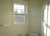 Thumbnail 6 of 21 - A white toilet sits in a bathroom next to a bathtub.