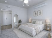 Thumbnail 16 of 38 - A bedroom with a large bed, a mirror, and two lamps.