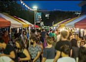 Thumbnail 7 of 10 - A busy night market with people walking and shopping.