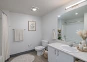 Thumbnail 38 of 38 - A bathroom with a toilet, sink, and mirror.