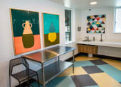 Thumbnail 10 of 25 - a room with a table and two paintings on the wall and a sink
