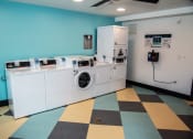 Thumbnail 9 of 25 - a laundry room with four washes and a washing machine