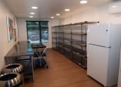 Thumbnail 13 of 25 - an empty room with two refrigerators and a table and chairs