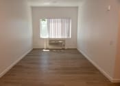 Thumbnail 2 of 25 - an empty room with wooden floors and a window