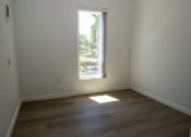 Thumbnail 4 of 25 - an empty room with a window and wooden floors