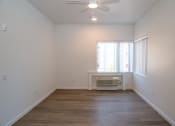 Thumbnail 6 of 25 - an empty living room with a ceiling fan and a window