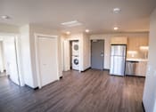 Thumbnail 6 of 16 - A kitchen area with a refrigerator, dishwasher, and washer.