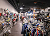 Thumbnail 14 of 16 - A clothing store with a variety of clothes on display.